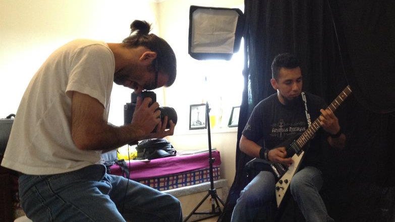 A photo of Márcio Faustino Santos in his studio photographing a musician playing eletric guitar.