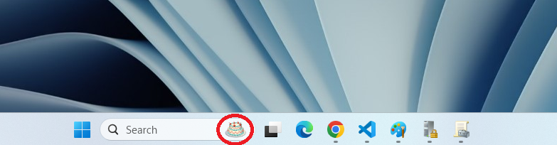 Screenshot of a Windows taskbar showing search bar with circled far-right icon of a birthday cake.