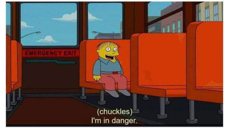An image of Ralph Wiggum from “The Simpsons”. He is sat at the back of the school bus, chuckling to himself because he is in danger and doesn’t understand the severity of his situation.