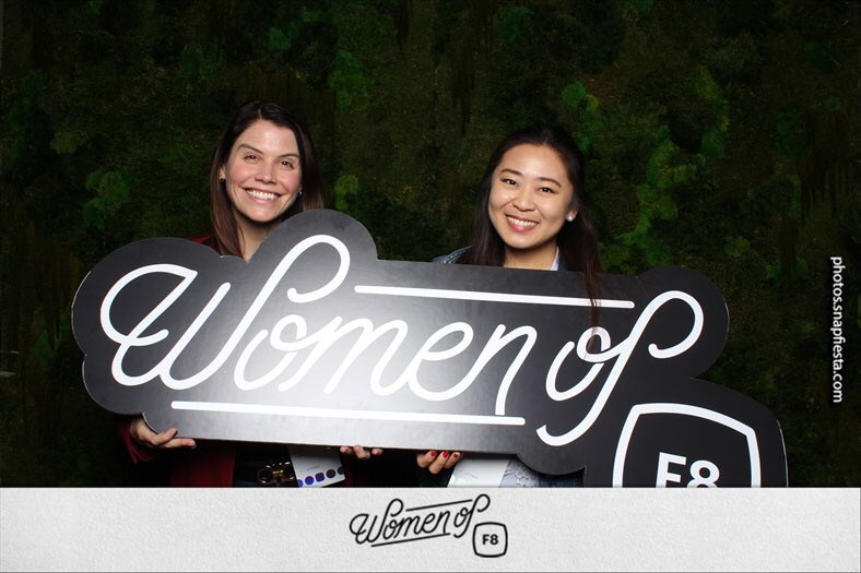Ad Councils Laurie Keith poses with fellow employee Julia Kim, holding a sign that says "Women of F8"