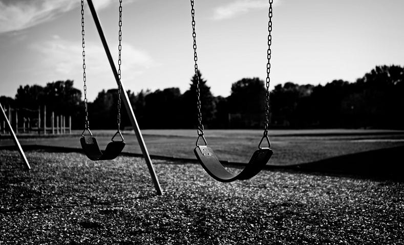 Deserted Playground with two empty swings in black and white