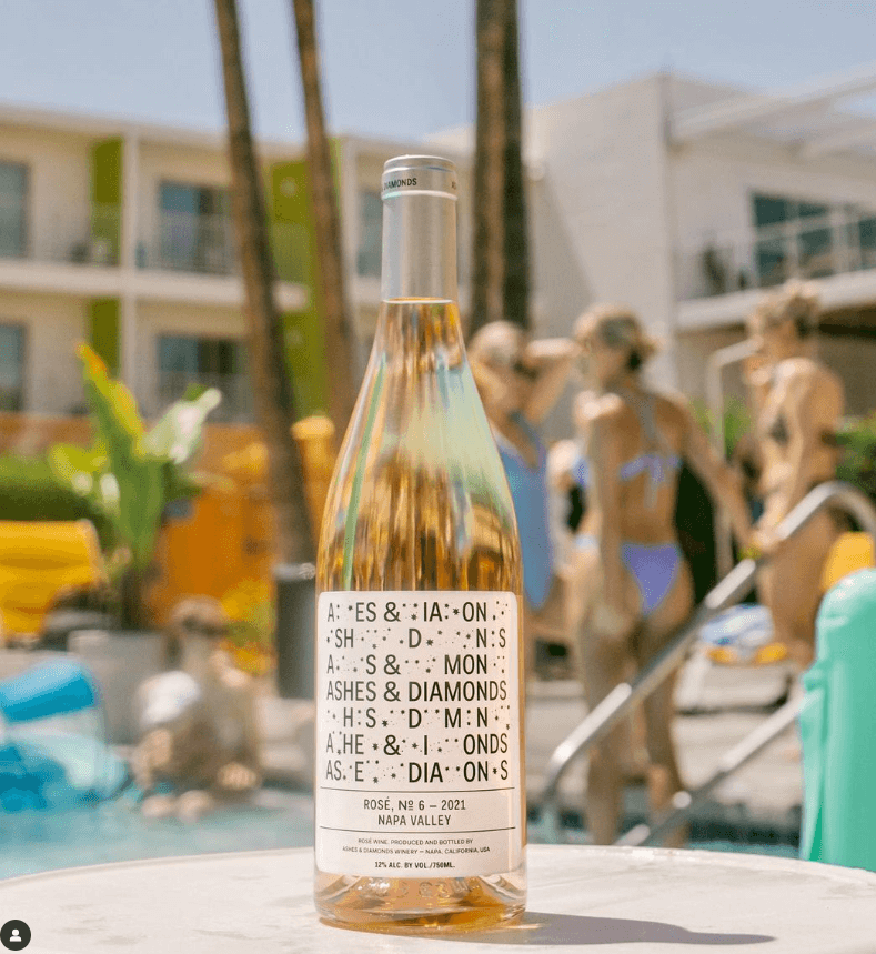 A picture of Ashes and Diamonds wine brand on a swimming pool with girls on bikinis.