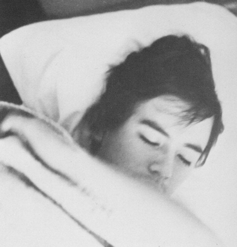 Photograph of, I believe, Kadur Alejandro Flores Murillo, sleeping in his bed in Washington, D.C., with the covers pulled up to cover his chin.