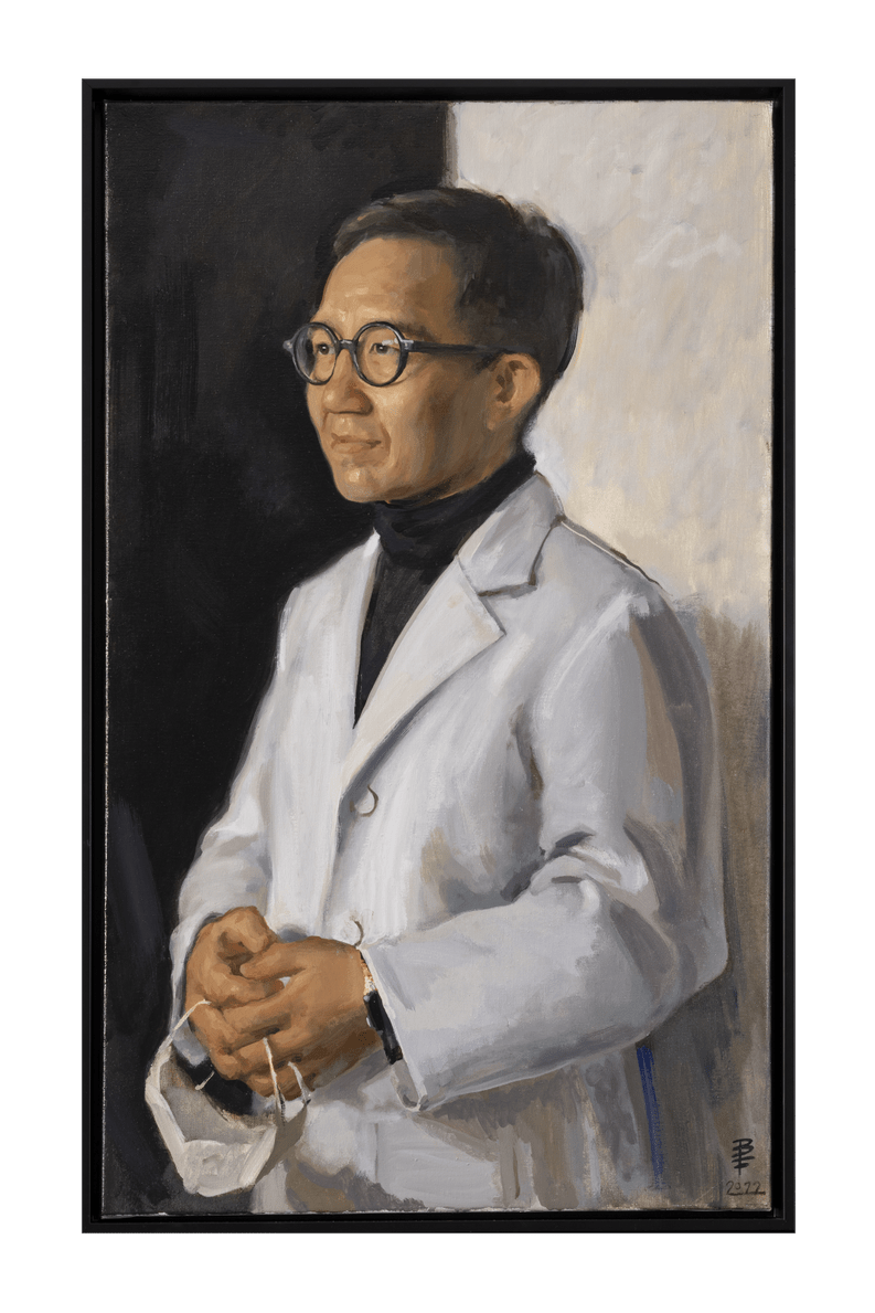 The portrait of Professor Gabriel Leung shows him wearing a doctor’s white coat over a black turtle neck. He holds a white face mask in his hands