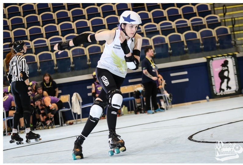 Professional sports photo of me sprinting through the apex in a roller derby game.