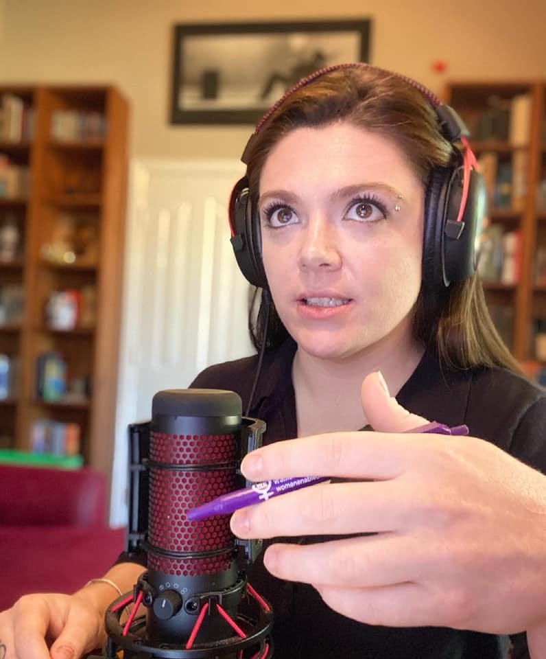 Author sits in a small library listening to audio and recording her own.