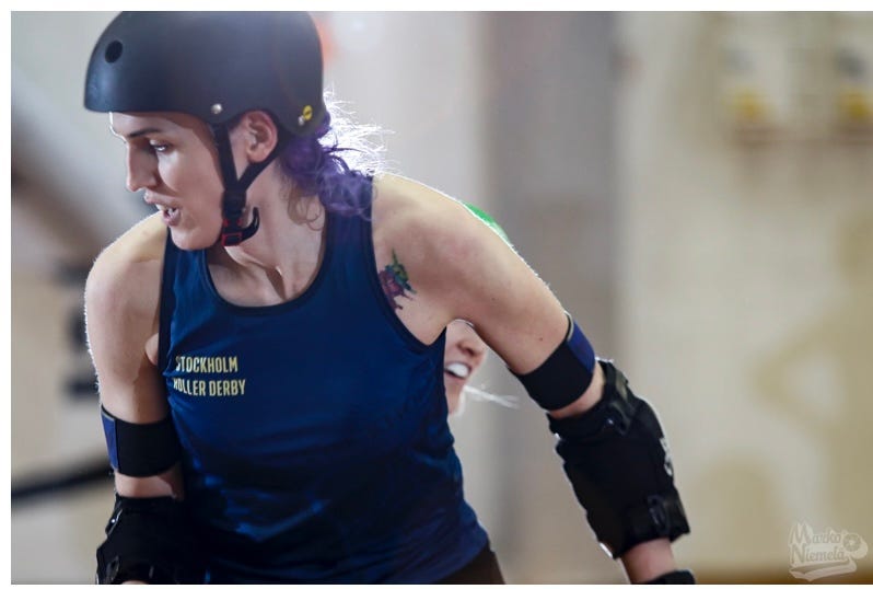 Professional sports photo of me in a roller derby game situation. I’m glancing over my right shoulder.