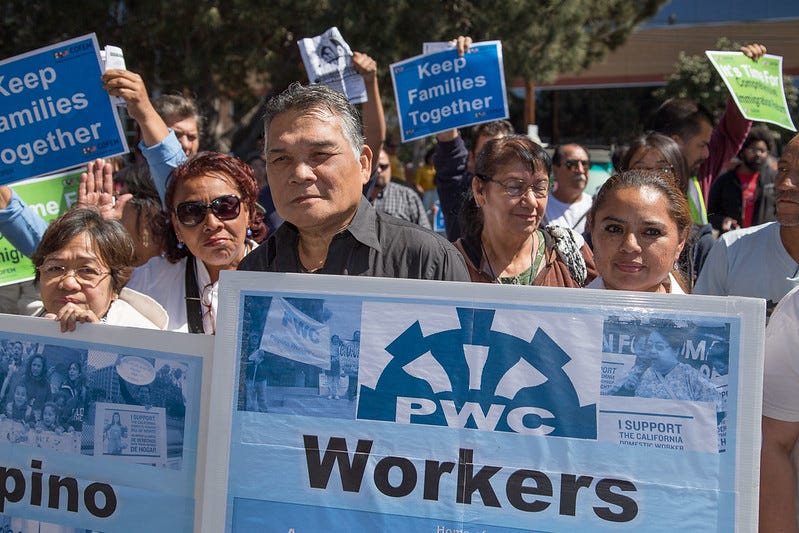 A group of immigrant workers holding protest signs