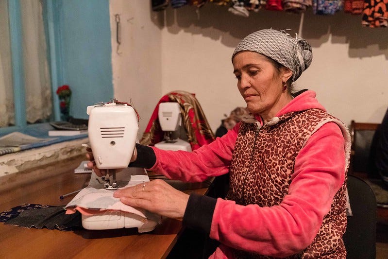 Roziyamo Kabirova sits in front of her sewing machine