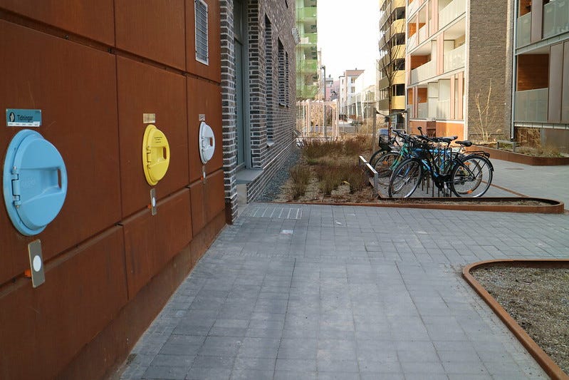 A side street in Royal Seaport features bicycle parking and waste chutes.
