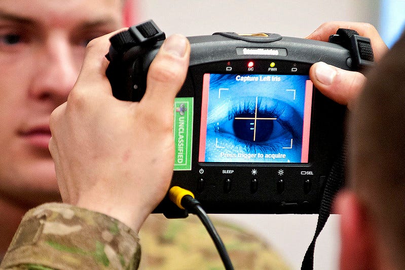 A handheld iris scanner scans the iris of a US soldier.