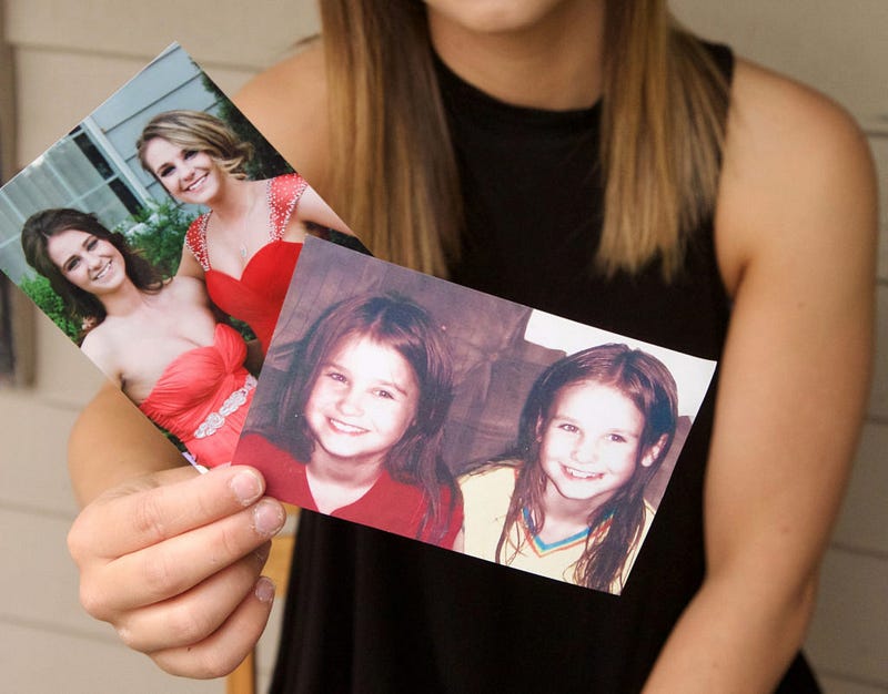  Since the day her sister passed, Jessica has collected Josie’s belongings such as photographs, artwork, clothing and personal diary entries. Above, Jessica compares photographs of her and her sister from when they were little, to their senior prom, photos she now greatly cherishes. Photo by Lauren Prater 