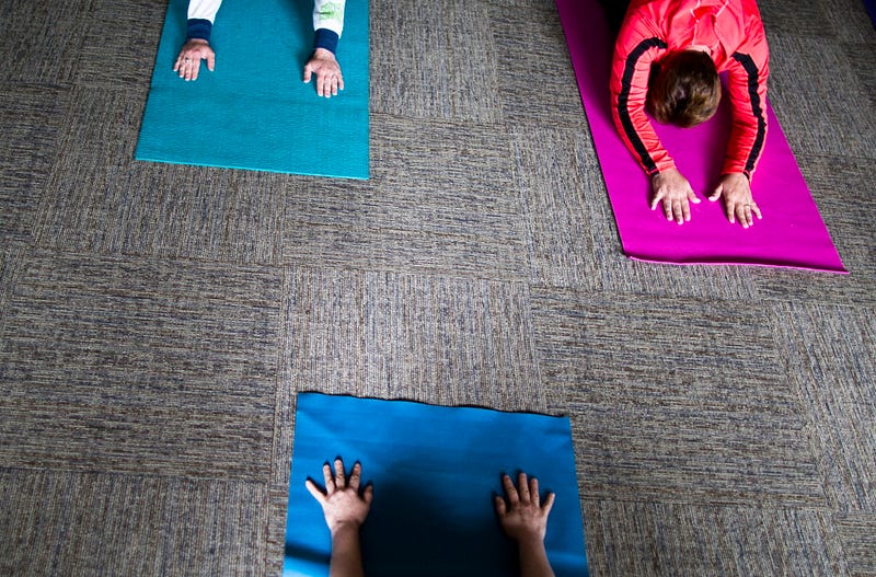 In a back room of Christ the Servant Lutheran Church, yoga instructor Abby Staten leads her students through child's pose during a morning class on May 22, 2015. 