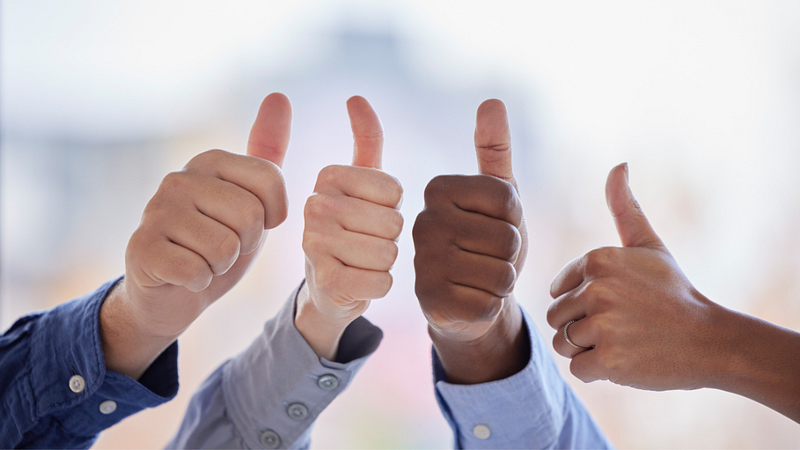 Four hands with their thumbs up.