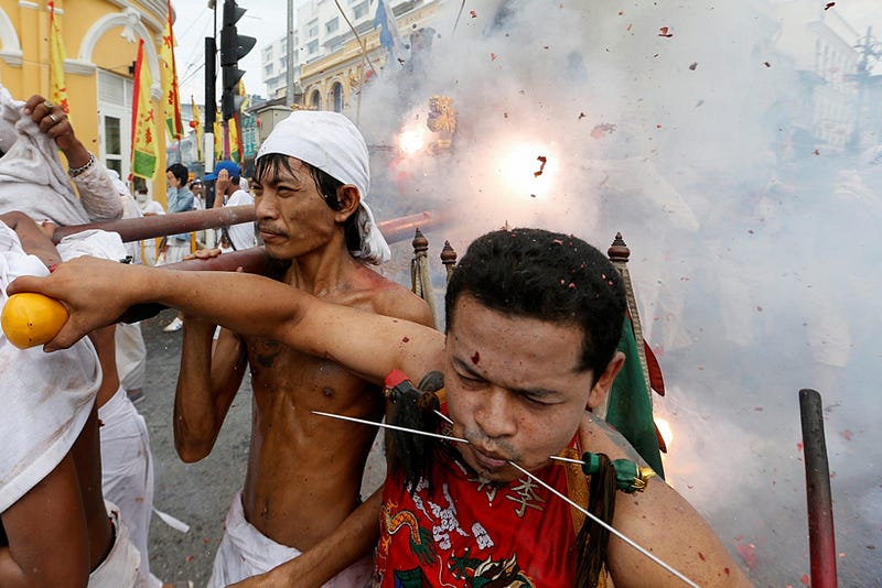 Devotees of the Chinese Ban Tha Rue shrine react while firecrackers explode behind them as they take part in a procession celebrating the annual vegetarian festival in Phuket, Thailand, October 5, 2016 . REUTERS/Jorge Silva
