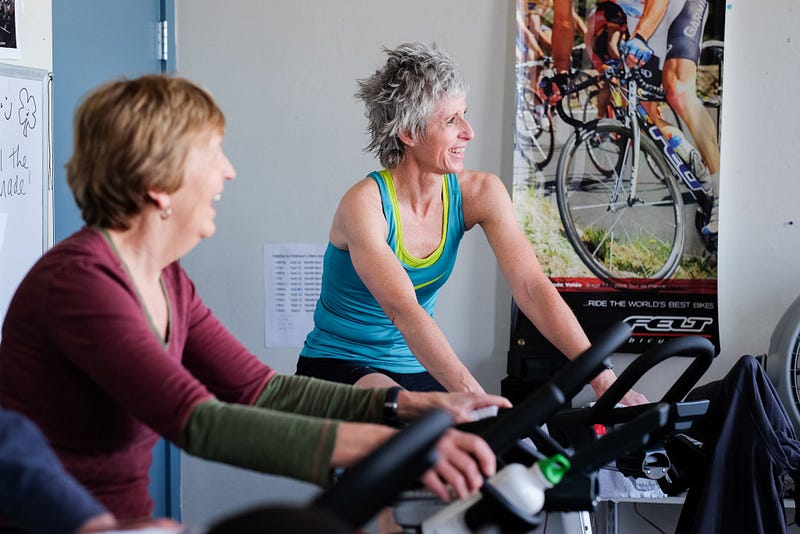 Tracy Dhiel, an instructor and leader of the Pedaling for Parkinson’s class at the YMCA, chats with participants during the hour bike ride. Studies have shown that spin classes like this one can help reduce symptoms for Parkinson’s by around 35%, according to the YMCA.