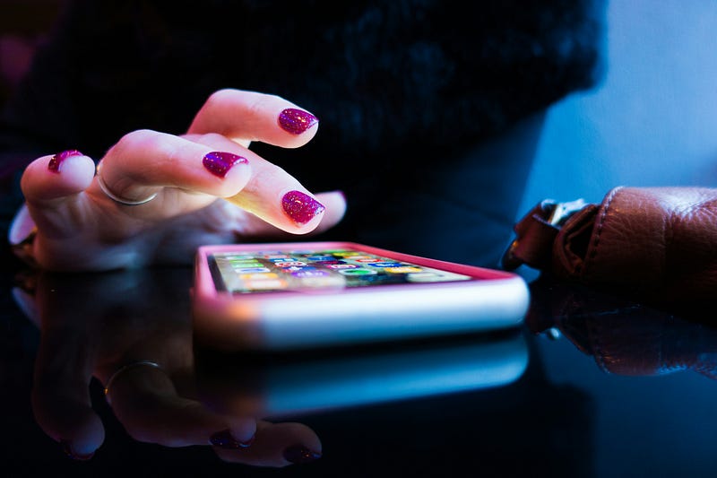 A close-up image of a hand tapping an app on a mobile phone.