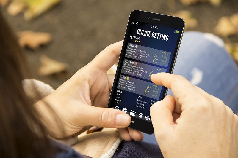 Image of women on phone looking at sports gambling screen.