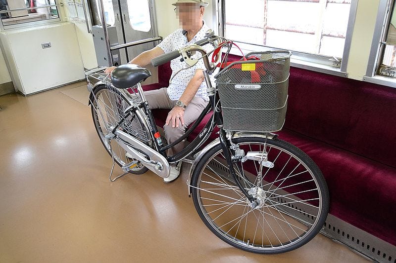 Anónimo japonés con su bici en el tren. Fuente: Wikimedia Commons.