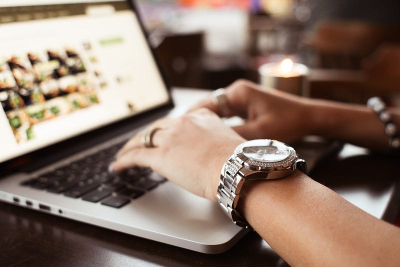 girl-with-watches-typing-on-macbook-picjumbo-com