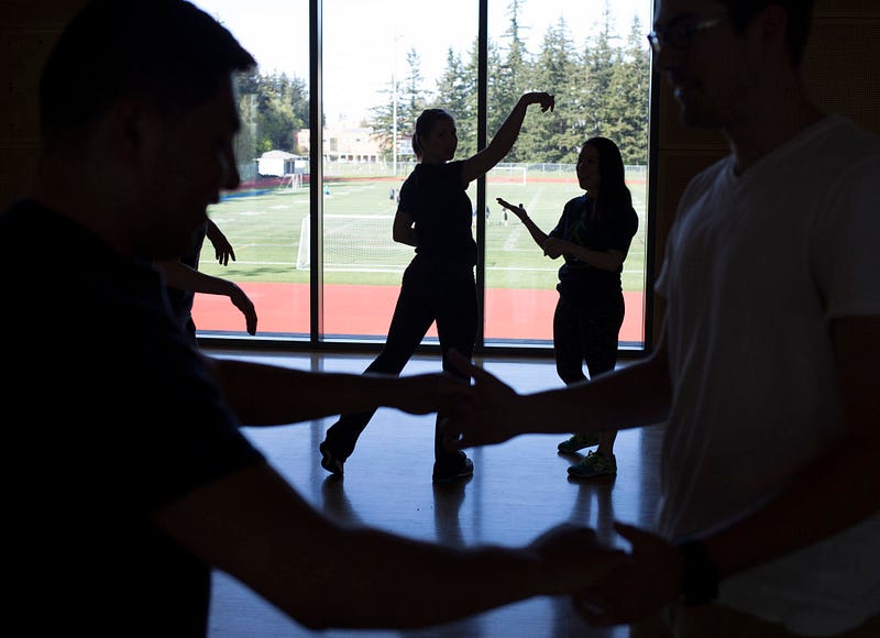 Participants in the First Step rehabilitation program are silhouetted as they dance during a class Wednesday, April 22, 2015 in the Wade King Student Recreation Center on Western's campus.