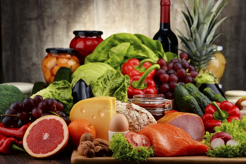 Variety of organic food including vegetables fruit bread dairy and meat. Balanced diet.