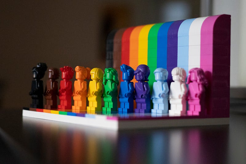Row of small plastic figures in all colors of the rainbow