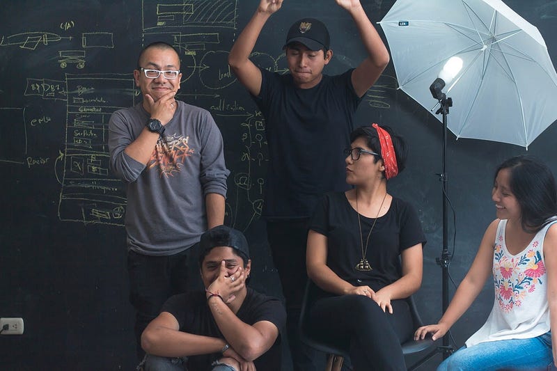 A team of employees in front of a black chalkboard