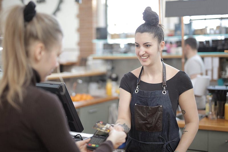 Woman paying with credit card at the market.