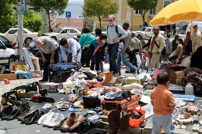 Items displayed on the ground during a sale at Feira da Ladra.