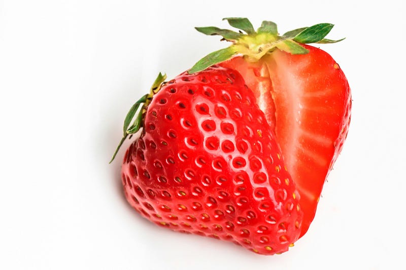 A single strawberry, cut in two.