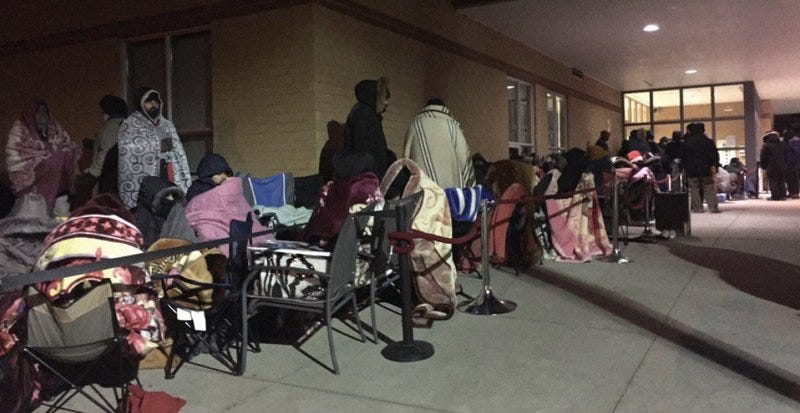 People line up outside a community centre to register for adult swimming lessons.