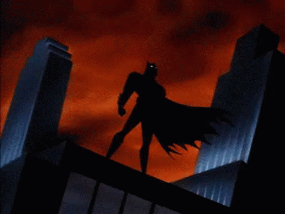 O Batman em cima de um prédio em uma noite tempestuosa