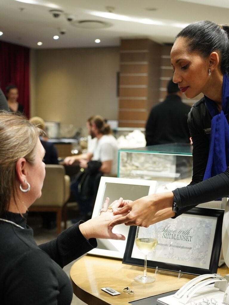 Customer trying imitation jewelry ring during a showroom consultation to understand fit, comfort, and final look before purchasing custom gold or diamond jewelry.