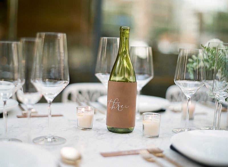 table number wine bottle - http://ruffledblog.com/downtown-dallas-rehearsal-dinner-inspiration