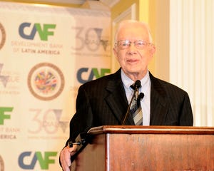 Former President Jimmy Carter standing at a podium.