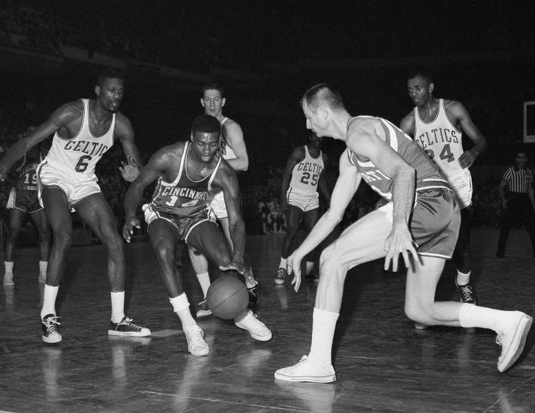 Oscar Robertson (middle) dribbles in an NBA game against the Boston Celtics.