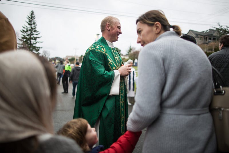 Prepared with smiles, small talk and blessings, Altenhofen shakes the hands of parishioners immediately following a Sunday mass at Sacred Heart Church. 