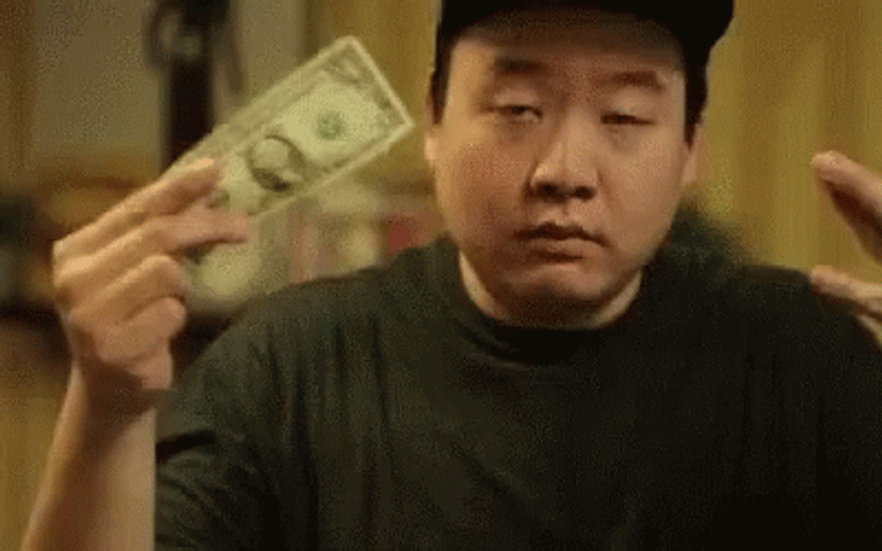 An asian guy, throwing money in a humurous way.