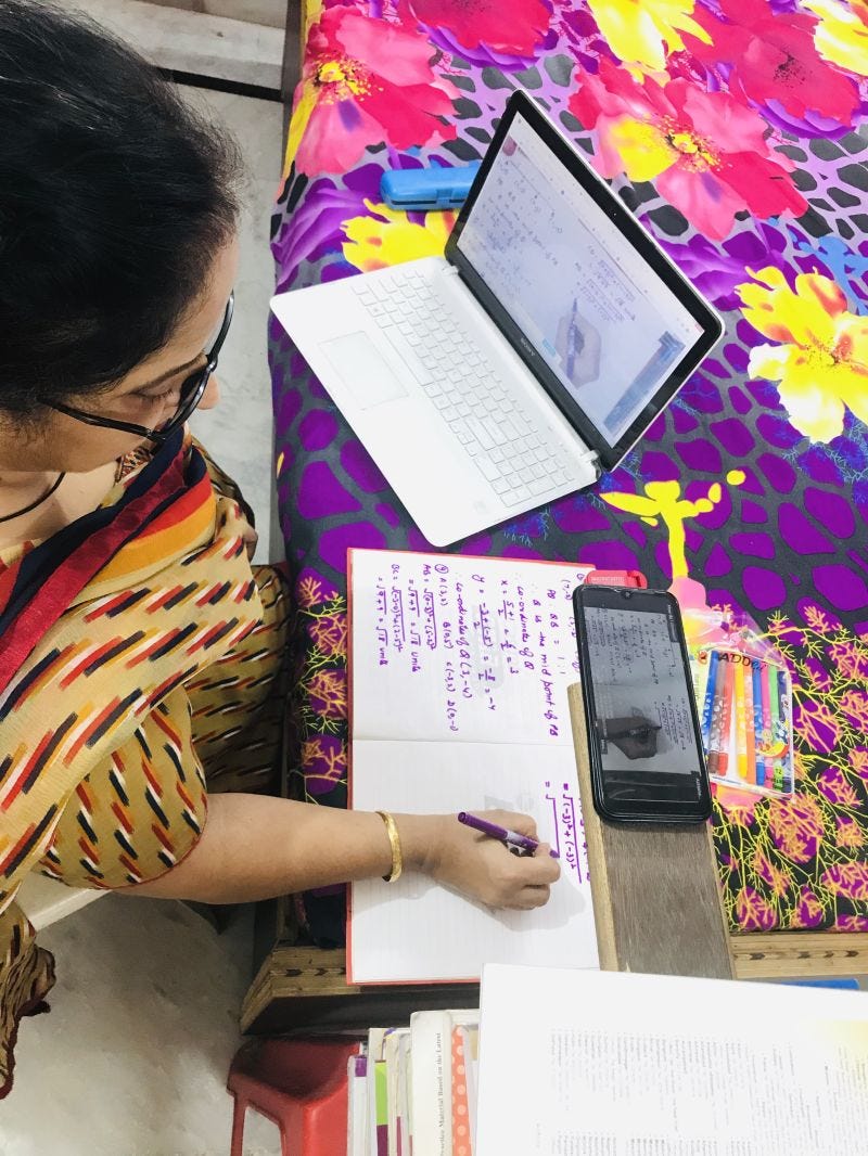 a teacher creating a projecting her handwritten notes by placing her phone on an elevated platform