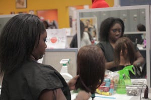 Cosmetology student Arnetris Thomas combs a mannequin's hair in the Laney College salon.