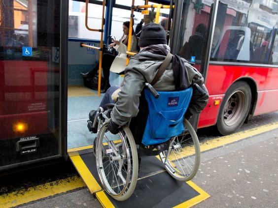 Man in wheelchair using a ramp to access a London bus