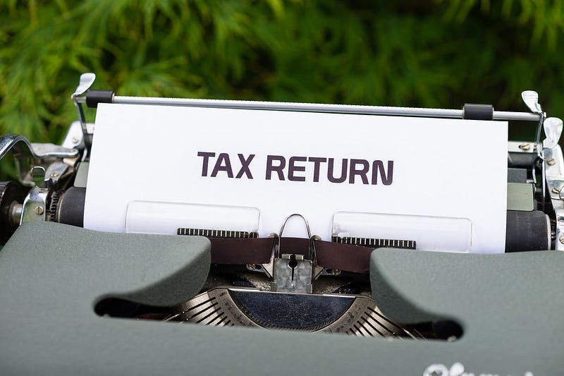 A typewriter with the words "tax return" displayed on a piece of paper