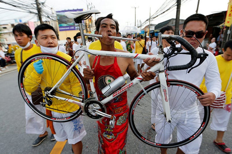 A devotee of the Chinese Samkong Shrine walks with a bike pierced on his mouth during a procession celebrating the annual vegetarian festival in Phuket, Thailand October 4, 2016. REUTERS/Jorge Silva TPX IMAGES OF THE DAY