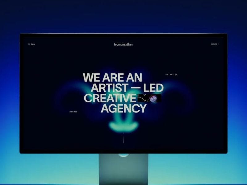 Dark creative agency website displayed on a screen with glowing blue gradients and bold centered text reading “We are an artist-led creative agency.”