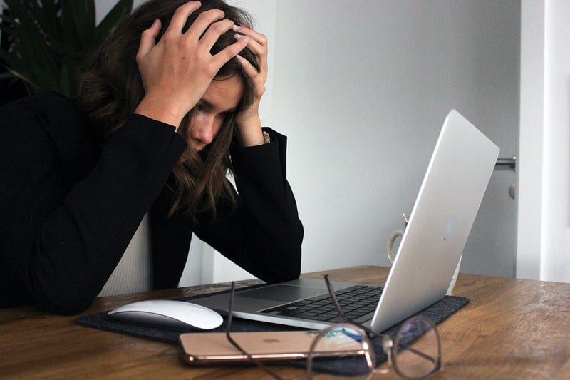 Frustrated woman staring at a computer screen.