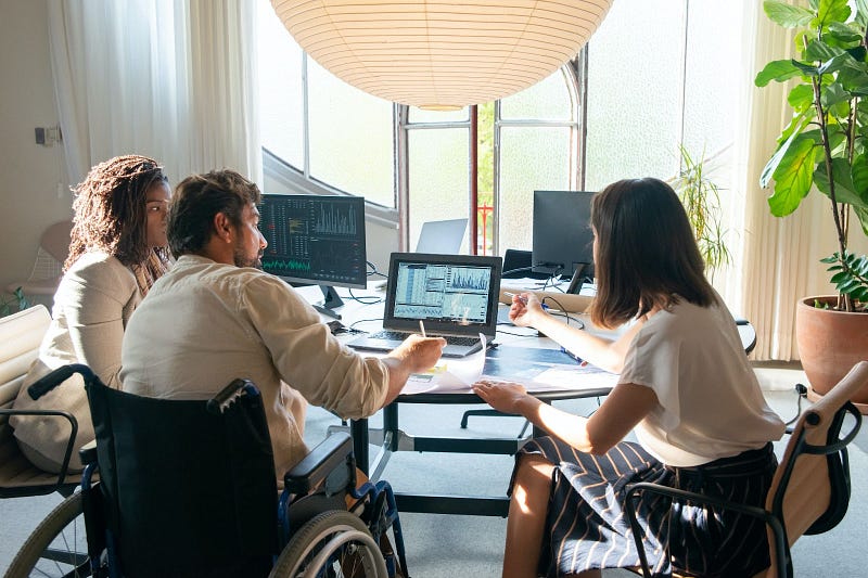 three people sitting around a table while planning their organizational development