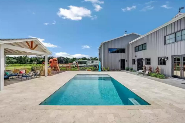 Backyard pool of Osceola County, Florida Barndominium by Leslie Mintrone 
