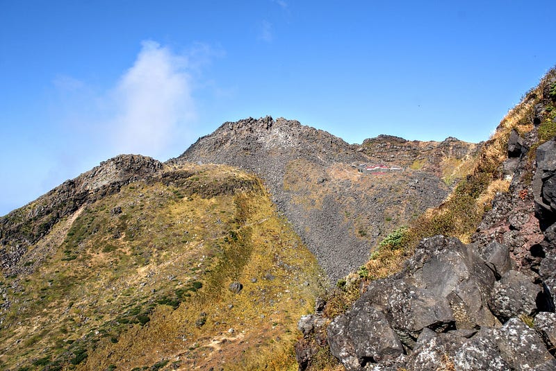 The rocky summit of Chokai-san (Mt. Chokai) with Omonoimi Jinja (shrine) at its foot.