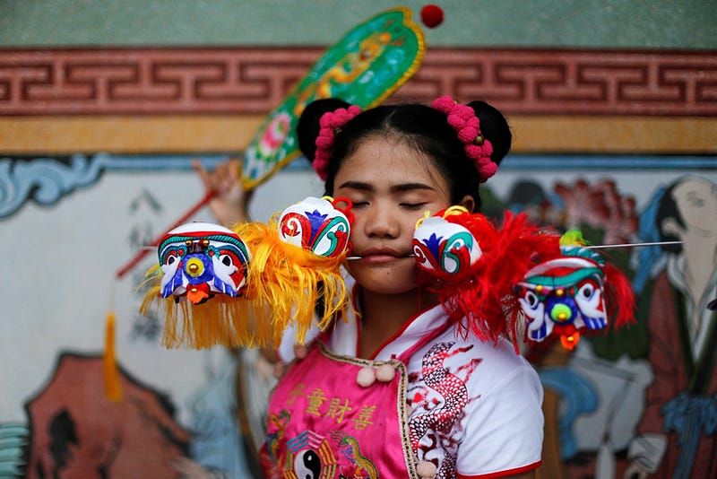 A devotee of the Chinese Ban Tha Rue shrine with piercings at her face takes part in a procession celebrating the annual vegetarian festival in Phuket, Thailand, October 5, 2016 . REUTERS/Jorge Silva